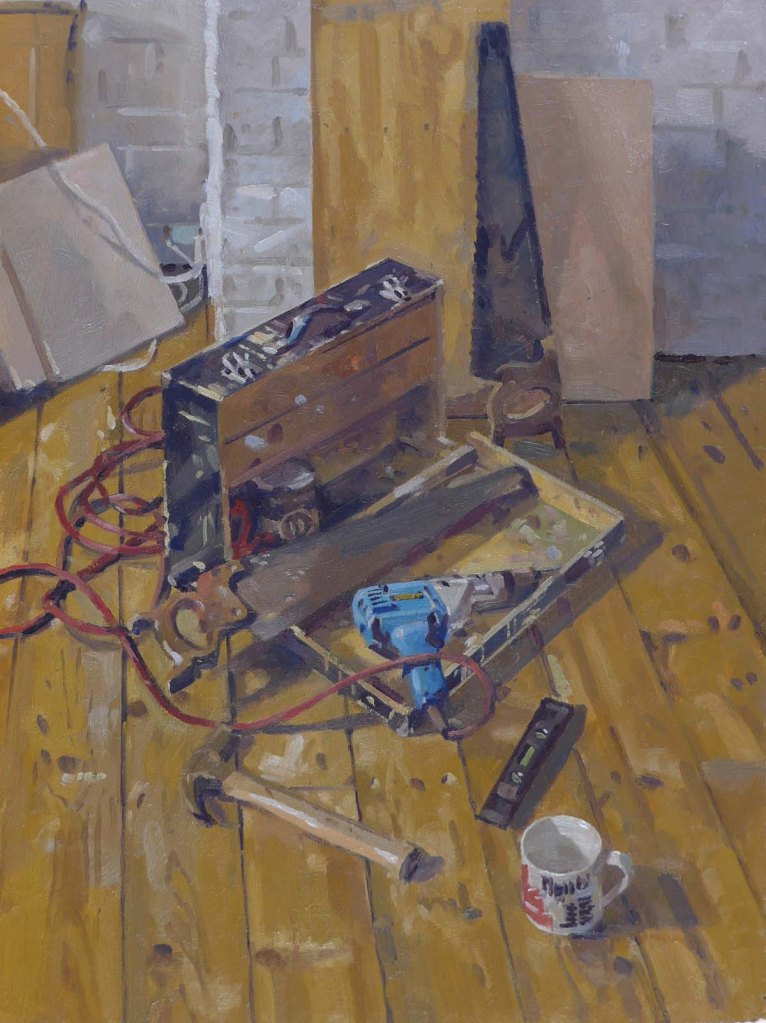 A still life of a black wooden carpenters tool box, which is open to reveal tools. A saw and a drill lay on the open box. The box stands on a wooden floor with a hammer and spirit level in the foreground. The painting is full of lively brushwork and is very well observed.
